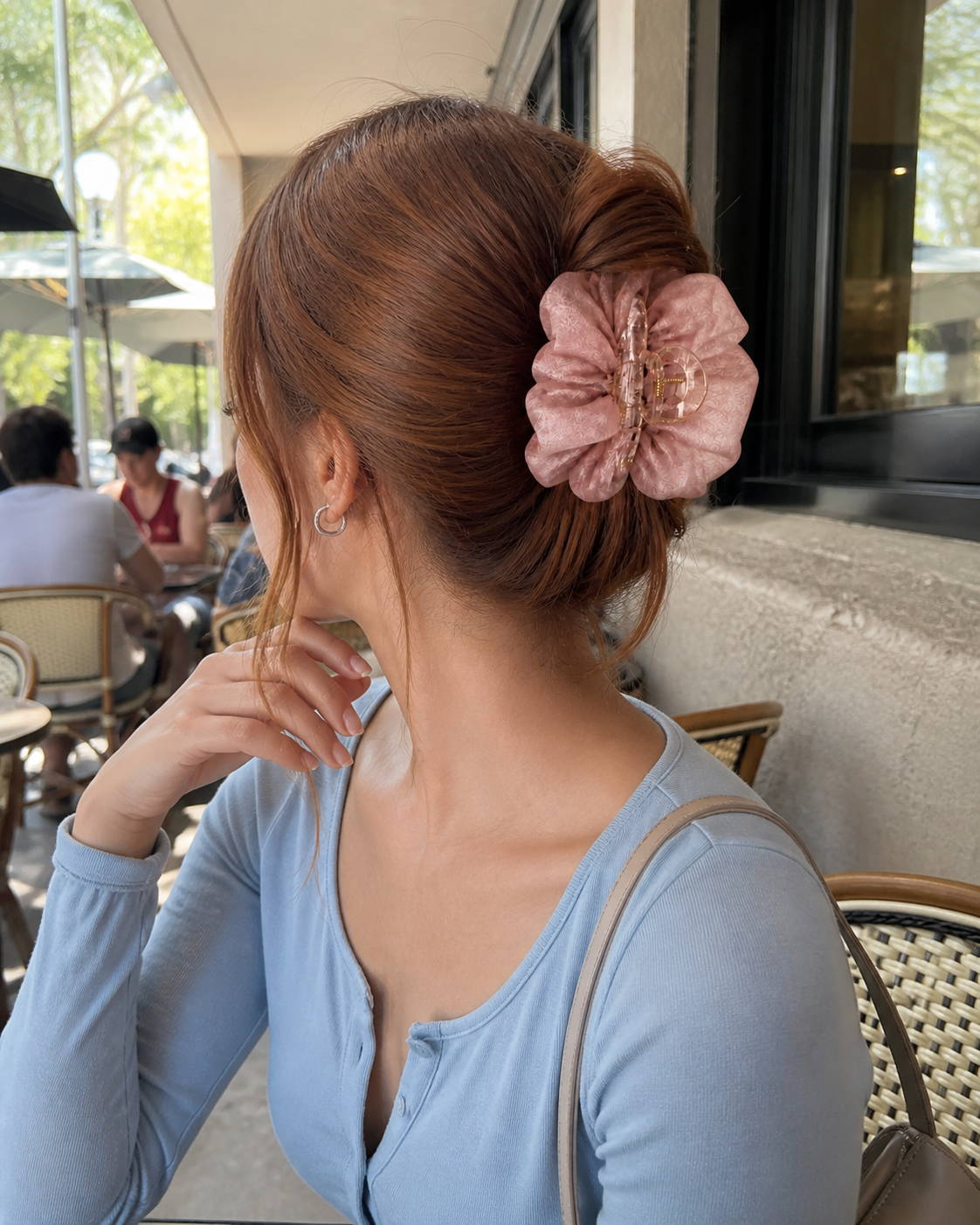 Blush Silk Cloud Claw Clip worn at an outdoor café